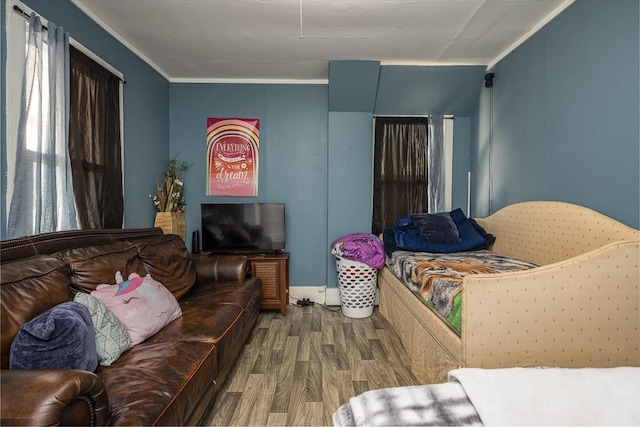 bedroom featuring ornamental molding and wood finished floors