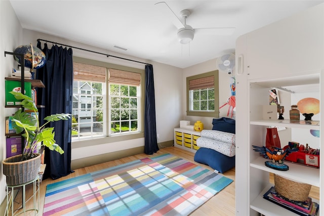 bedroom with wood finished floors, a ceiling fan, and baseboards