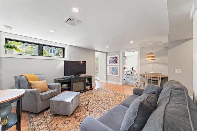 living area with light wood-style flooring and recessed lighting