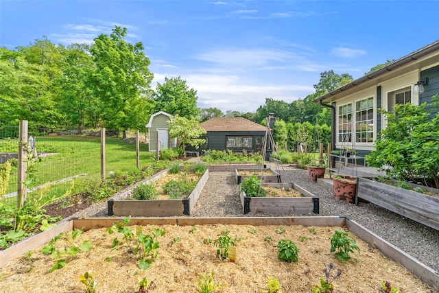 view of yard featuring a vegetable garden, a storage shed, and an outdoor structure