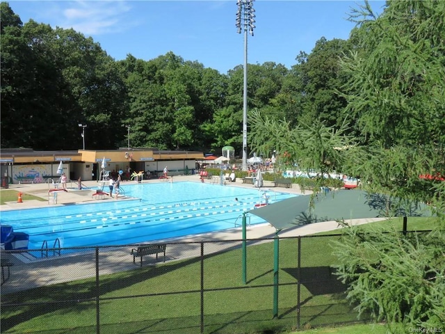 community pool with fence and a patio area