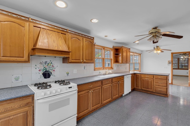 kitchen featuring decorative backsplash, a ceiling fan, white appliances, custom range hood, and a sink