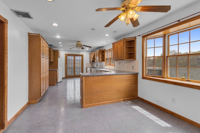 kitchen featuring plenty of natural light, baseboards, ceiling fan, and open shelves