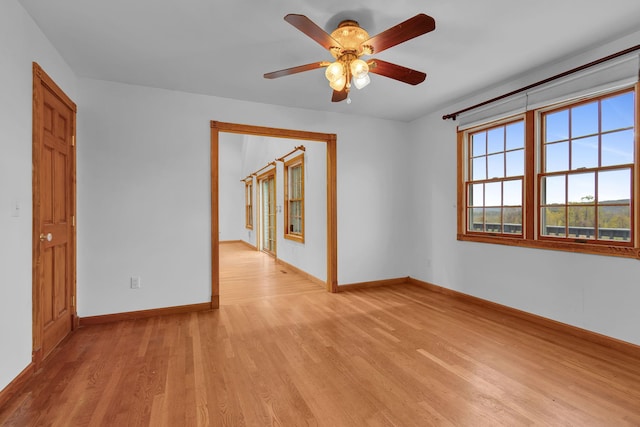 unfurnished room featuring baseboards, ceiling fan, and light wood-style flooring