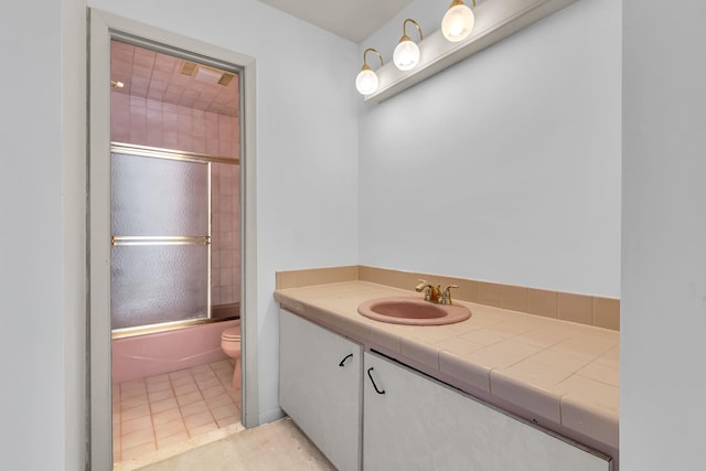 full bathroom with toilet, tile patterned flooring, shower / bath combination with glass door, and vanity