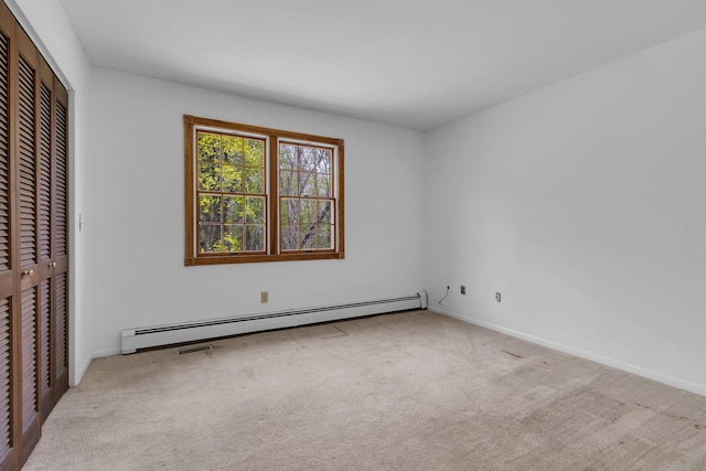 unfurnished bedroom with a closet, baseboards, carpet, and a baseboard heating unit