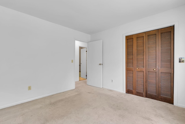unfurnished bedroom featuring carpet flooring, baseboards, and a closet
