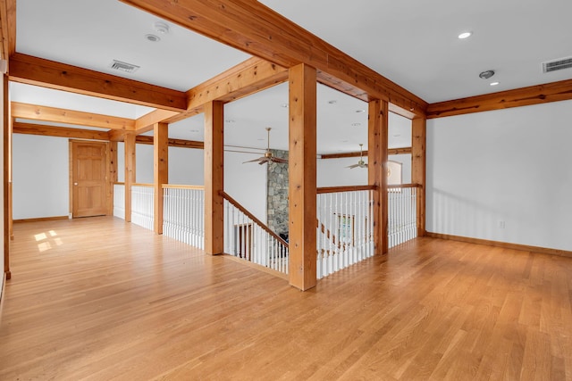 interior space featuring baseboards, a ceiling fan, light wood-type flooring, and visible vents
