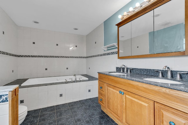 full bathroom featuring toilet, tile walls, a sink, and a garden tub