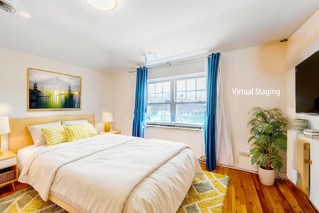 bedroom with visible vents and hardwood / wood-style flooring
