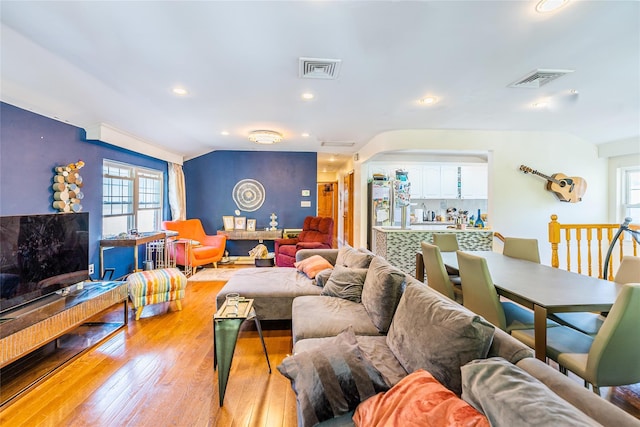 living room featuring visible vents, recessed lighting, light wood-style flooring, and lofted ceiling