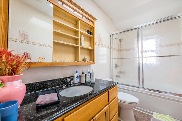 bathroom featuring vanity, decorative backsplash, toilet, tile walls, and enclosed tub / shower combo