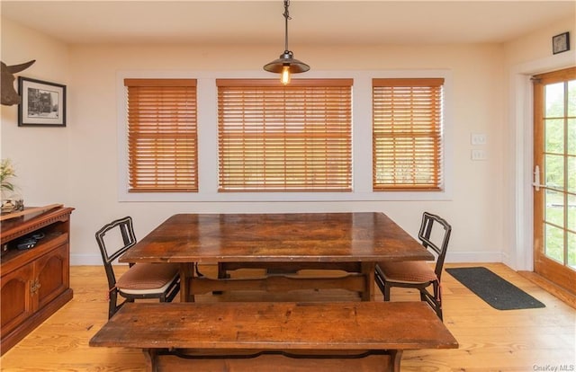 dining room featuring baseboards and light wood-type flooring