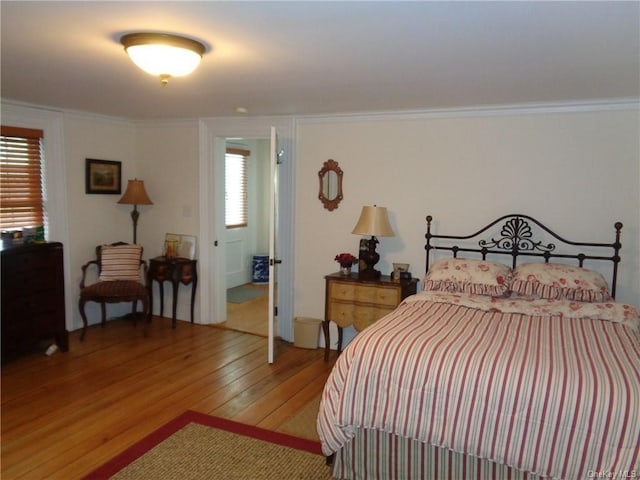 bedroom with light wood-style floors and ornamental molding