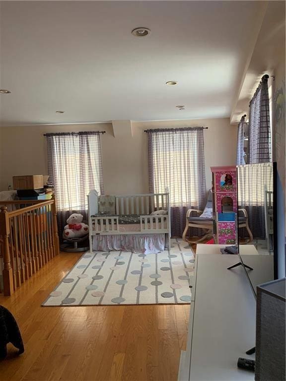 bedroom with multiple windows and wood finished floors