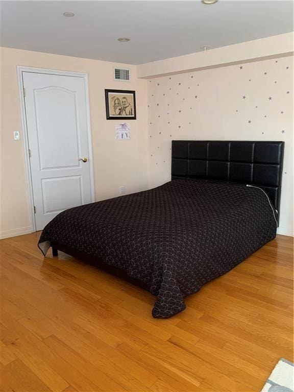 bedroom featuring light wood-style floors and visible vents