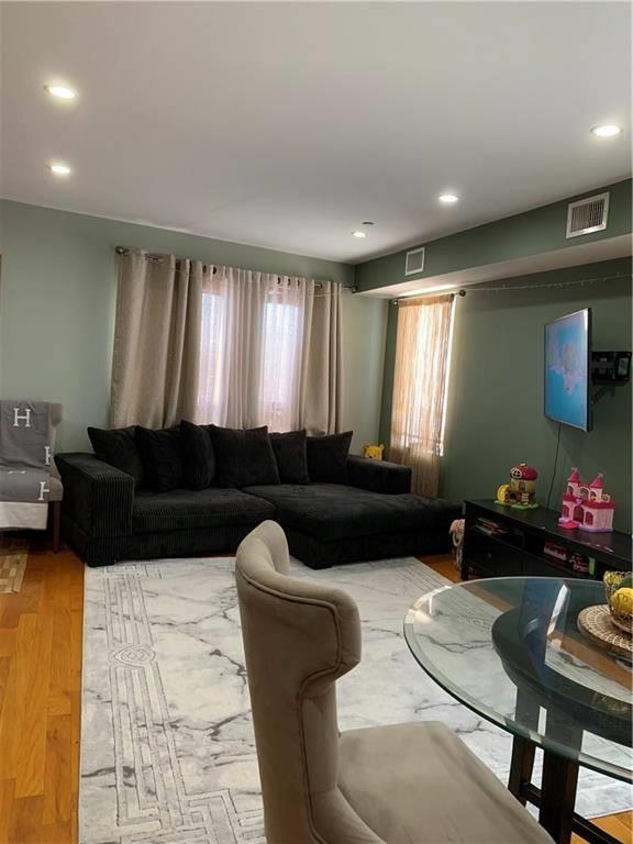 living area featuring recessed lighting, wood finished floors, and visible vents