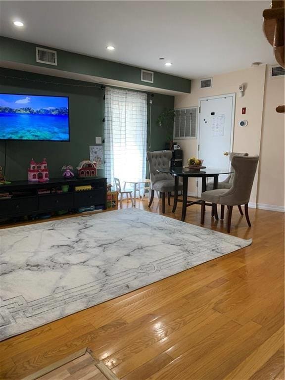living area featuring visible vents and wood finished floors