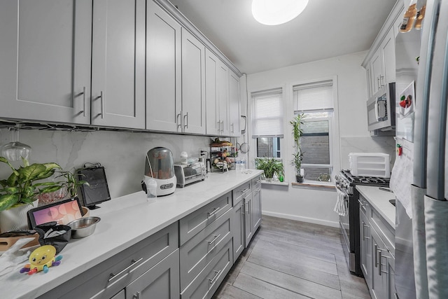1754 Seward Ave, Bronx, NY 10473 - kitchen with light countertops, gray cabinets, stainless steel appliances, and light wood-type flooring