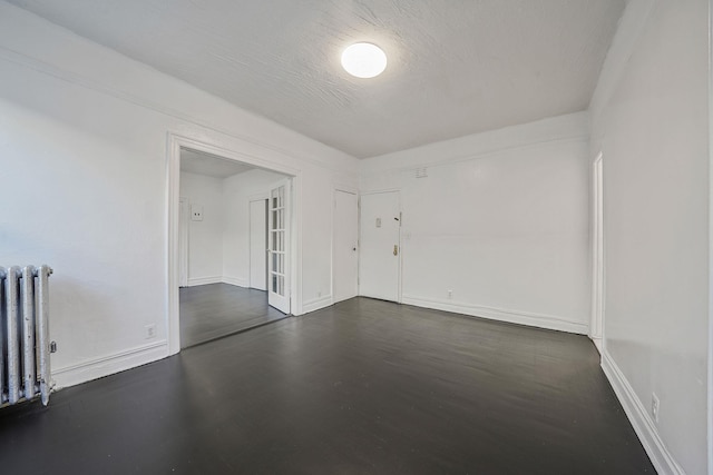 1754 Seward Ave, Bronx, NY 10473 - unfurnished room with radiator, baseboards, and dark wood-style flooring