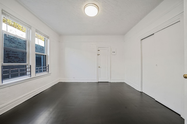 1754 Seward Ave, Bronx, NY 10473 - unfurnished room featuring a textured ceiling, baseboards, and dark wood-type flooring