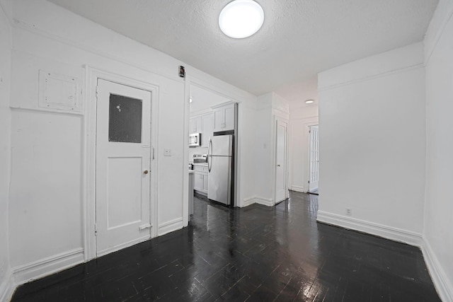 1754 Seward Ave, Bronx, NY 10473 - unfurnished room featuring baseboards, a textured ceiling, and dark wood-type flooring