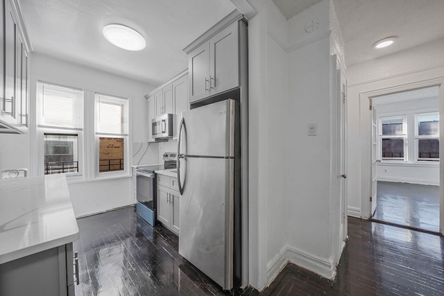 1754 Seward Ave, Bronx, NY 10473 - kitchen featuring light countertops, appliances with stainless steel finishes, gray cabinets, and dark wood-type flooring