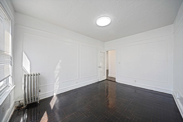 1754 Seward Ave, Bronx, NY 10473 - empty room featuring a textured ceiling, radiator heating unit, and a decorative wall