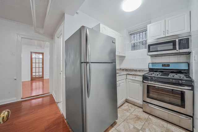 1754 Seward Ave, Bronx, NY 10473 - kitchen with decorative backsplash, light stone countertops, stainless steel appliances, and white cabinetry