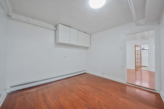 1754 Seward Ave, Bronx, NY 10473 - empty room with baseboards, wood finished floors, and baseboard heating