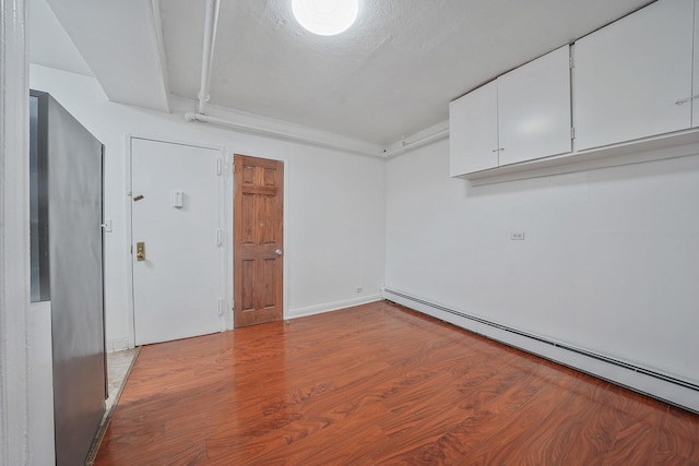 1754 Seward Ave, Bronx, NY 10473 - empty room with baseboards, baseboard heating, and wood finished floors