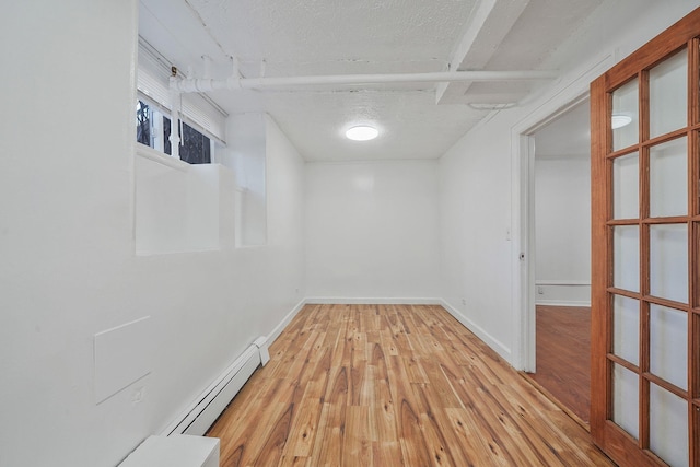 1754 Seward Ave, Bronx, NY 10473 - interior space featuring baseboards, a textured ceiling, light wood-style flooring, and a baseboard heating unit