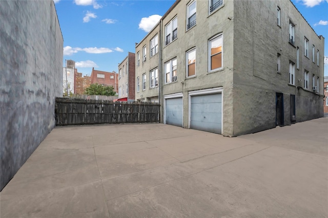 1754 Seward Ave, Bronx, NY 10473 - view of building exterior with fence, driveway, and a garage