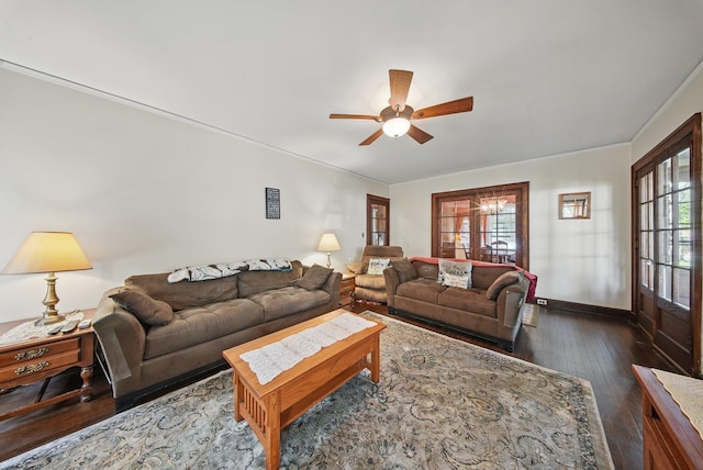 living area featuring baseboards, a ceiling fan, and dark wood finished floors