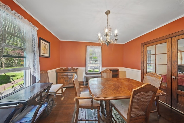 dining space featuring crown molding, an inviting chandelier, wainscoting, and radiator