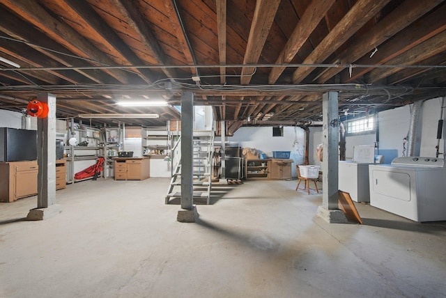below grade area featuring washing machine and clothes dryer
