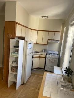 83-44 Lefferts Blvd Unit 6M, Kew Gardens, NY 11415 - kitchen featuring a sink, light countertops, extractor fan, freestanding refrigerator, and range with gas cooktop