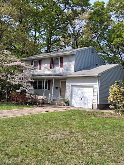 traditional home with an attached garage, a front lawn, and covered porch