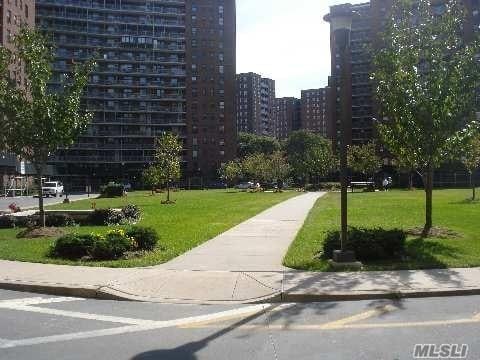 61-55 98th St Unit 8D, Rego Park, NY 11374 - view of property's community featuring a lawn and a city view