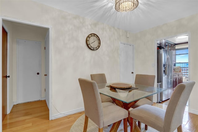 61-55 98th St Unit 8D, Rego Park, NY 11374 - dining space featuring light wood-style flooring, a chandelier, and baseboards
