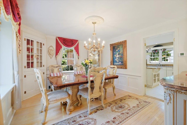 82 E Cedar St, Poughkeepsie, NY 12601 - dining room featuring light wood-style floors, a chandelier, healthy amount of natural light, a decorative wall, and a wainscoted wall