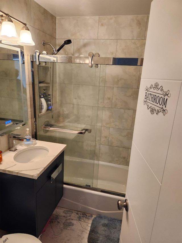 bathroom featuring combined bath / shower with glass door and vanity