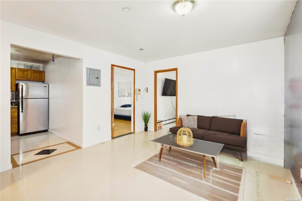 living room with electric panel, baseboards, and a baseboard heating unit