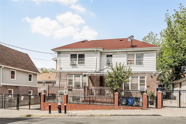607 E 226th St, Bronx, NY 10466 - view of front of property with brick siding, cooling unit, a fenced front yard, and a gate