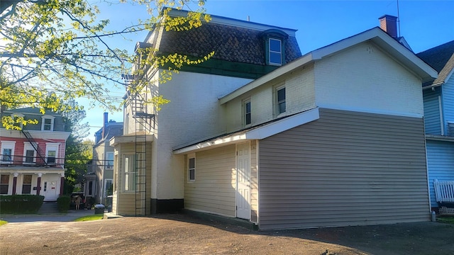 107 Garden St, Poughkeepsie, NY 12601 - rear view of property featuring brick siding and mansard roof