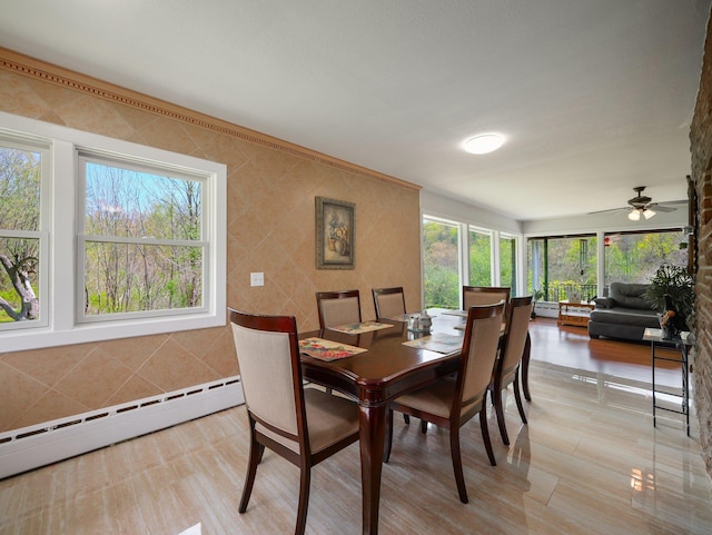 dining area with ceiling fan and baseboard heating