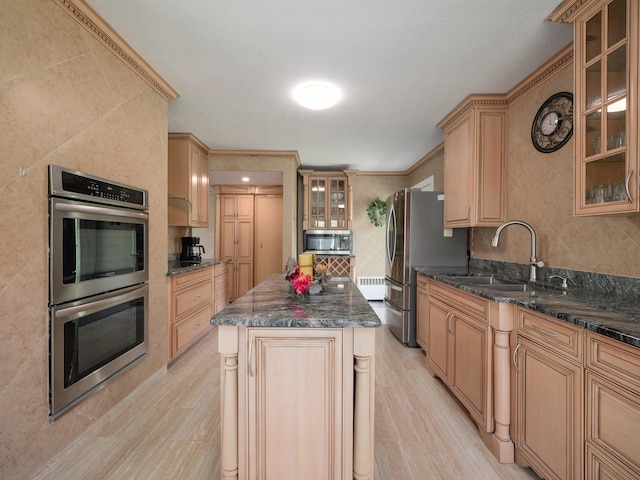 kitchen with a sink, stainless steel appliances, tasteful backsplash, a kitchen island, and glass insert cabinets