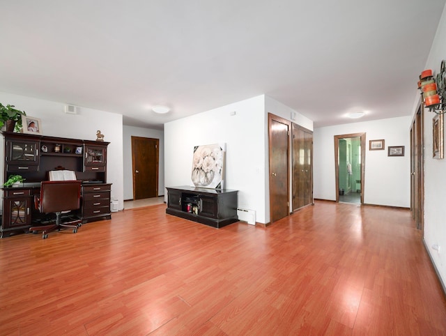 office area featuring light wood-type flooring, a baseboard radiator, and visible vents