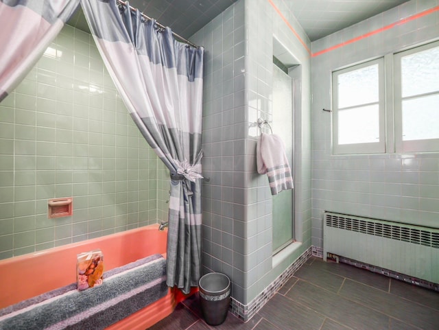 full bathroom featuring tile walls, shower / bathtub combination with curtain, and radiator heating unit