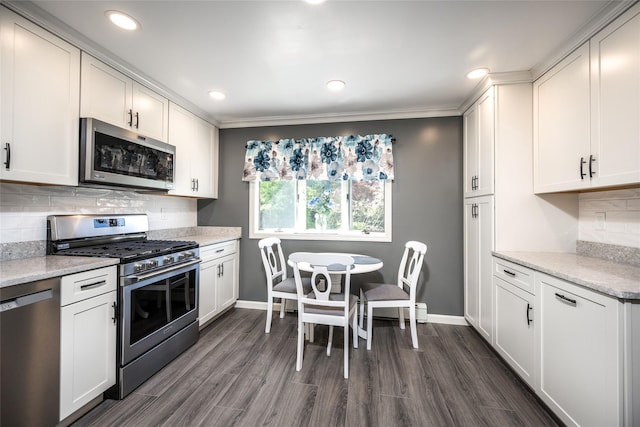 kitchen with baseboards, stainless steel appliances, and dark wood finished floors